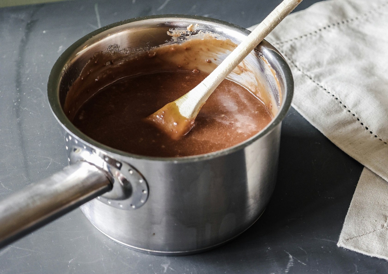 Stock photo of a saucepan with brown soup/gravy inside.