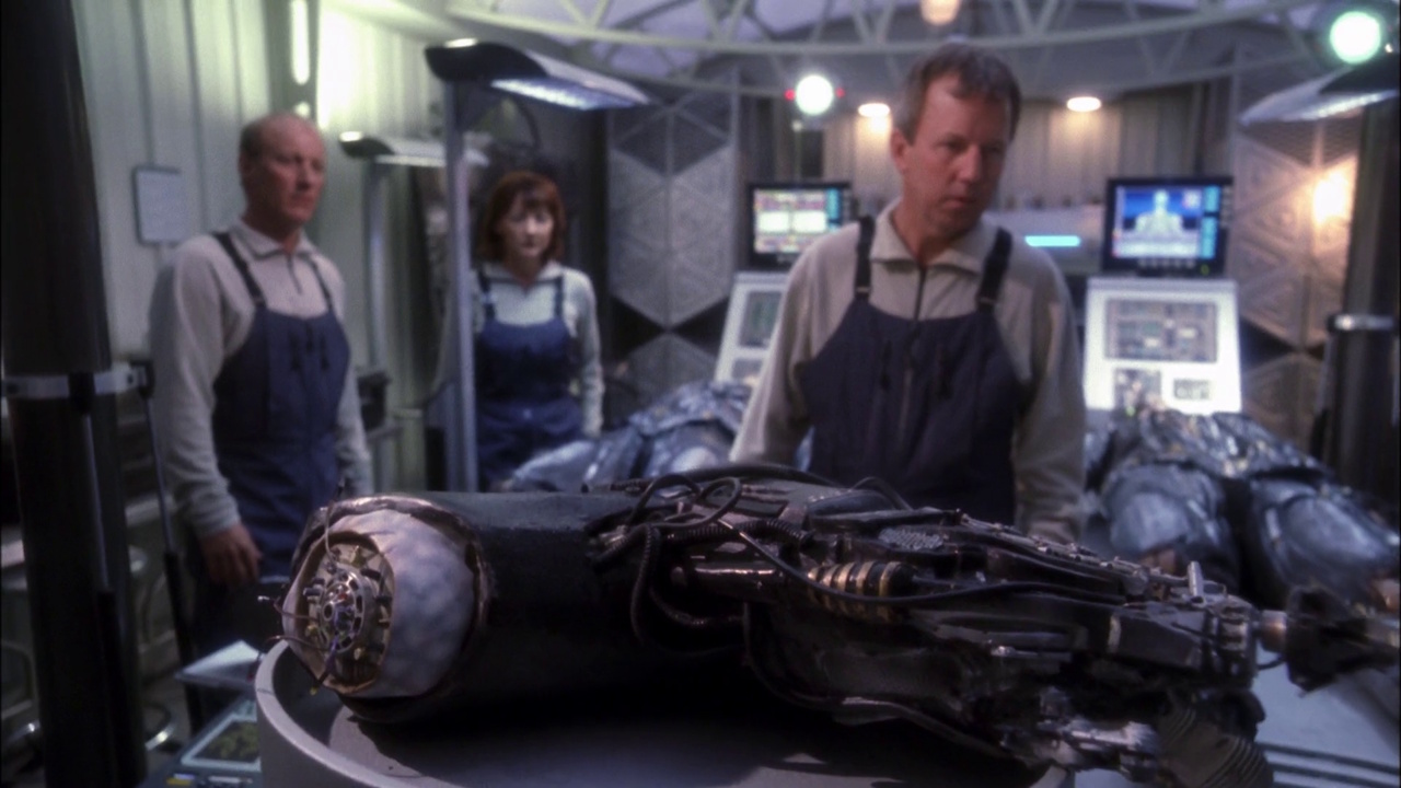 Still frame from Star Trek: Enterprise (Regeneration) showing scientists and a Borg arm.