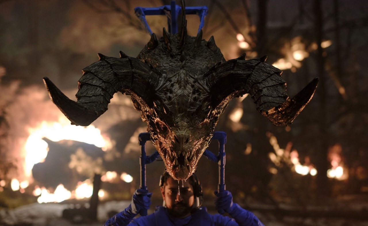 Behind-the-scenes photo from Fallout S2 showing a Deathclaw and puppeteer.