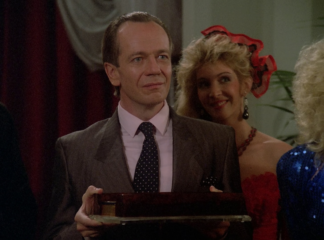 Still frame from Star Trek TNG The Royale showing the assistant manager