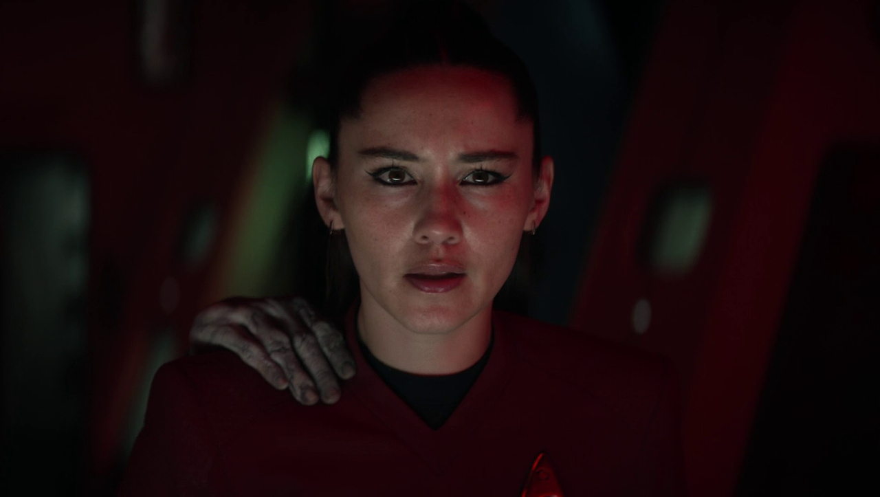 Still frame from Star Trek SNW 4x02 showing La'an with a ghostly hand on her shoulder