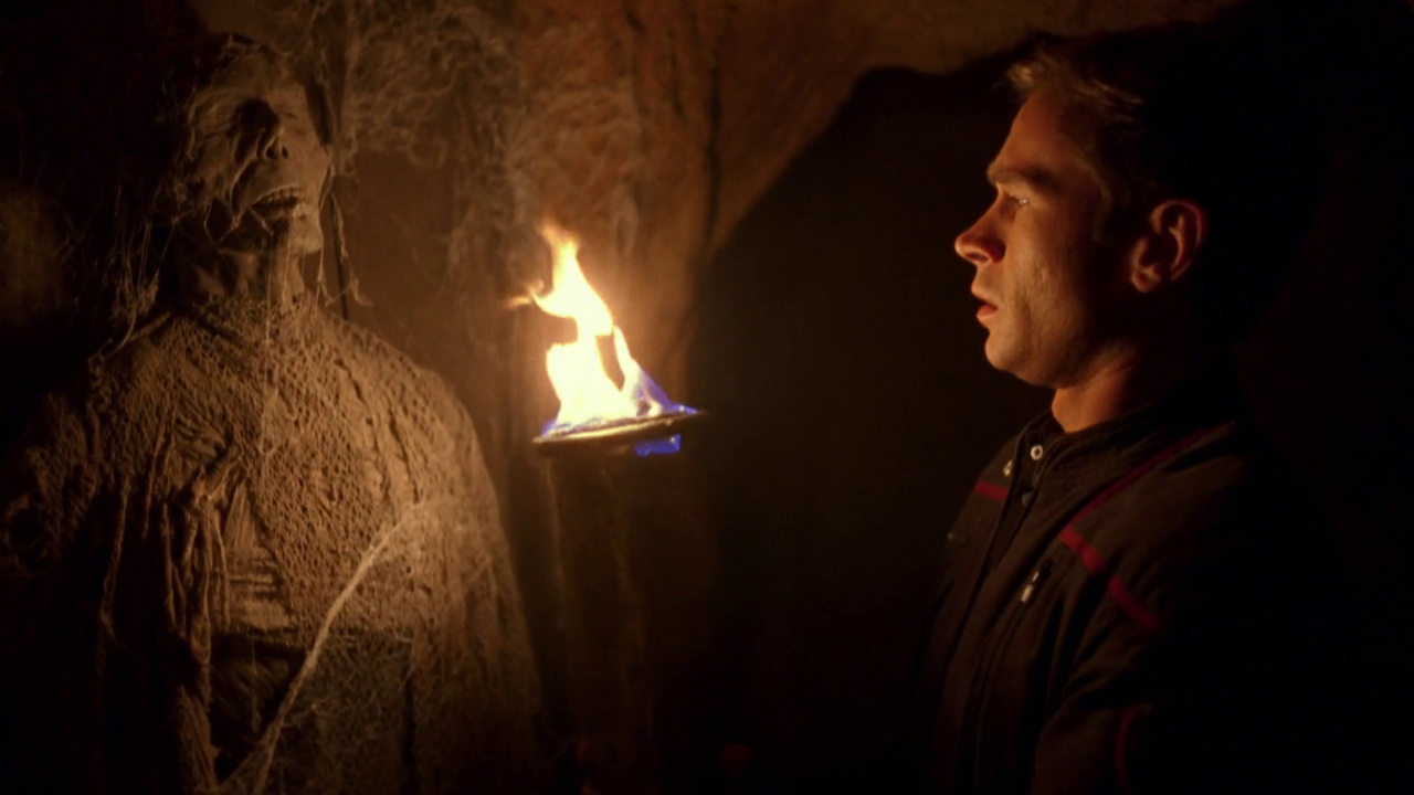 Still frame from Star Trek ENT 1x07 showing Trip holding a torch in front of a mummy