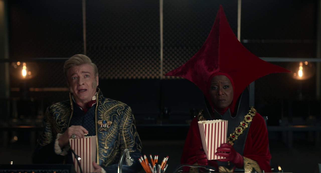 Still frame from Star Trek SNW 4x07 showing Trelane and his Q mentor eating popcorn