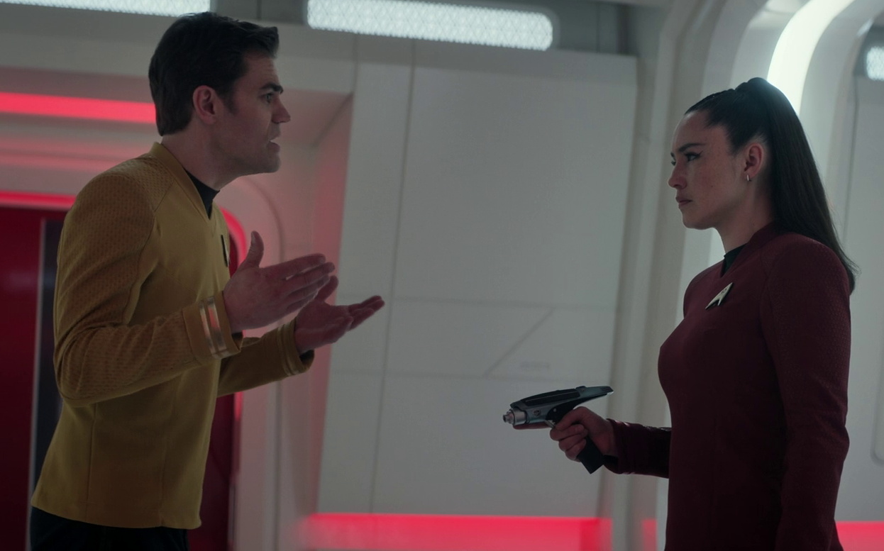 Still frame from Star Trek SNW 4x08 showing La'an pointing a phaser at Kirk
