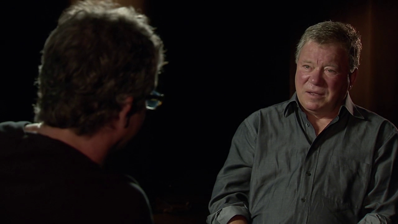 Still frame from Chaos on the Bridge showing William Shatner interviewing Brannon Braga