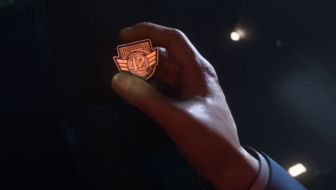 Still frame from the Squadron 42 promo trailer showing a hand holding a badge